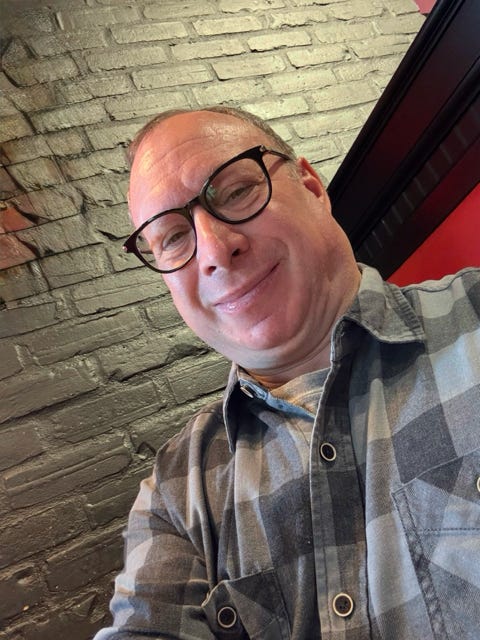 A head and shoulder's picture of Jordan H. Green with a grey brick wall behind him.